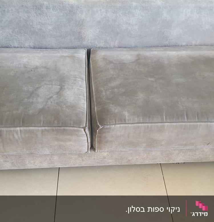 ספה אפורה עם כריות מושב על רצפת אריחים